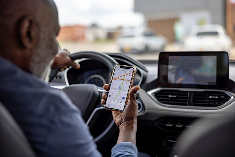 Rear view of a senior man using a navigation app while driving his car - transportation concepts