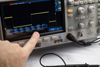 Engineer checking a detector signal on an oscilloscope