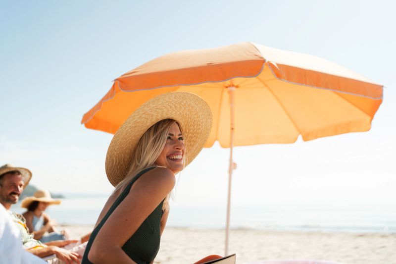 Photo of a young women who is relaxing on a hot summer day by the sea, accompanied by her closest friends