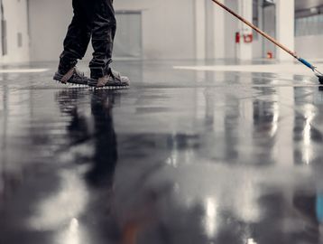 Person wearing spiked shoes working on a wet floor.