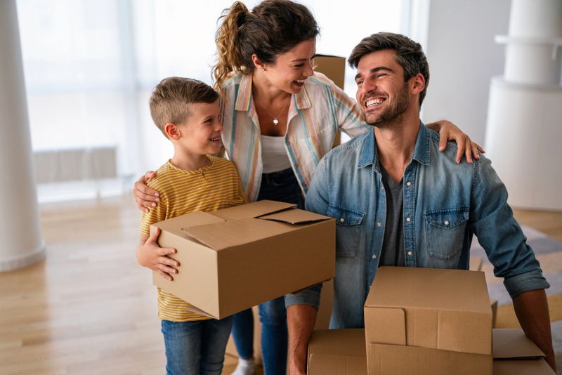 New home, box and parents with child in new house, property mortgage and real estate investment. Homeowner, family excited for moving day, relocation and rental concept
