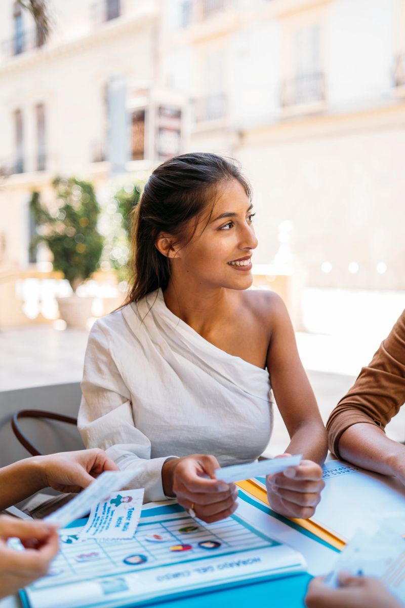 Group of university exchange students planning a trip abroad, holding brochures and choosing destinations