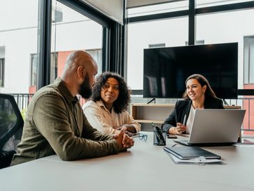 Three colleagues engaged in a meeting in a modern office.
