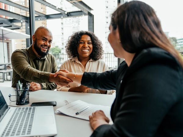 Three professionals sitting around a table in discussion.