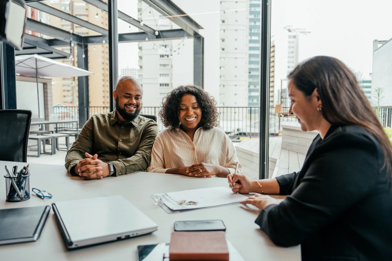 Couple closing real estate contract with real estate agent