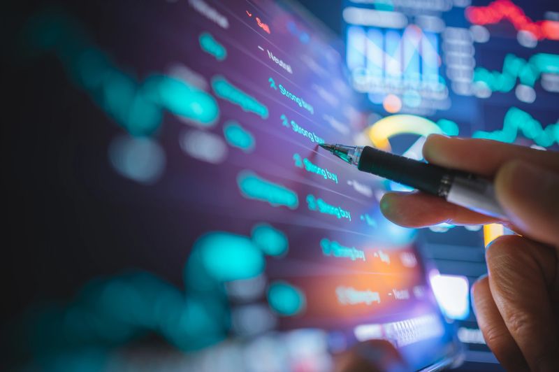 Financial advisor interacts with a digital interface displaying machine learning data insights.  AI's practical role in business strategy, performance evaluation, and predictive analysis. collaboration between technology and business expertise.