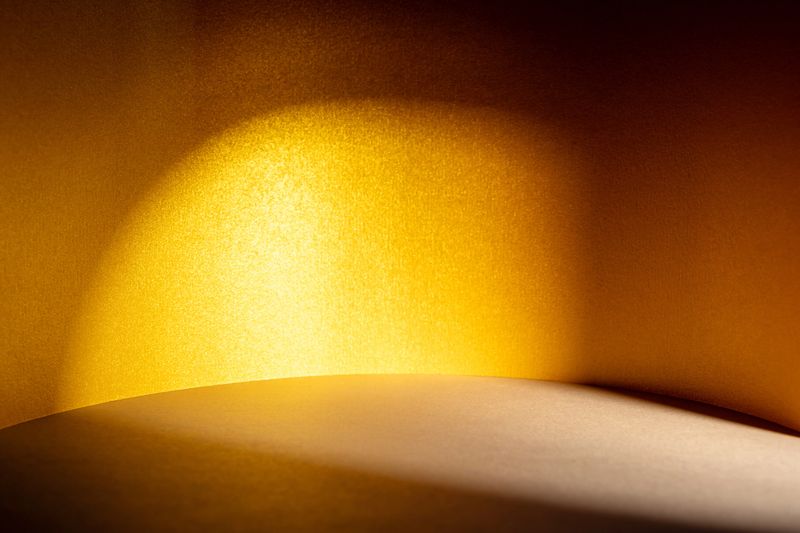 Play of golden hour sunlight and shadow on gold textured surfaces creating warm background.