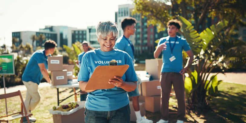 Volunteers organizing supplies outdoors on a sunny day.