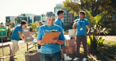 Volunteer organizing supplies outdoors.