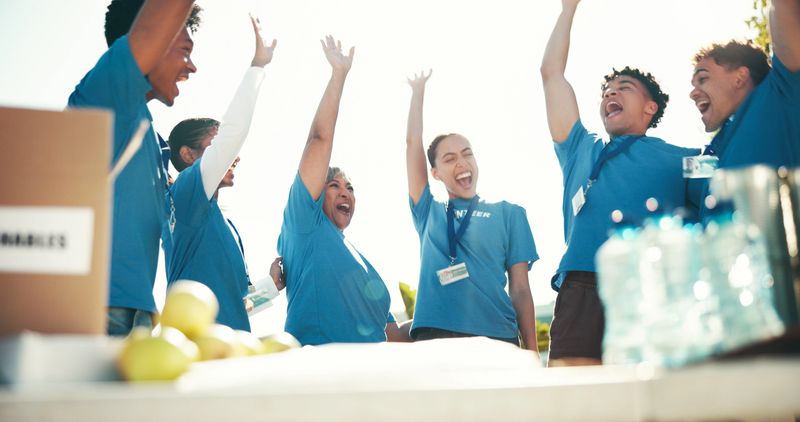 Cheering, volunteers and success for charity, group and celebration for fundraiser, team and donations. Outdoor, coordinator and achievement for community service, people and excited for nonprofit