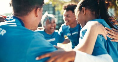 Group of volunteers in blue shirts enjoying a moment together.