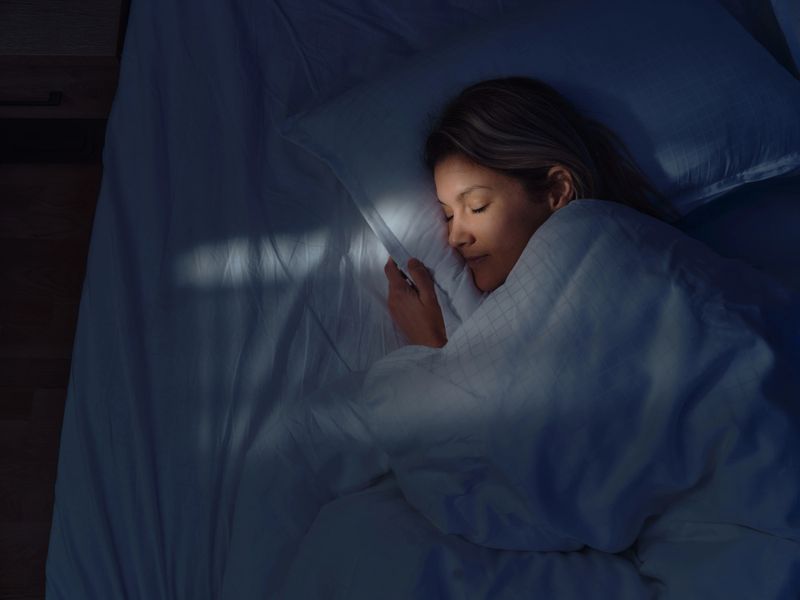 High angle view of a woman taking a nap in her bed at night. Photographed in medium format.