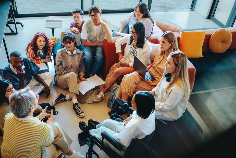 A diverse group of Generation Z classmates gathered in an informal setting, promoting teamwork and learning in a contemporary space.