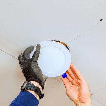 Installing a recessed ceiling light fixture.