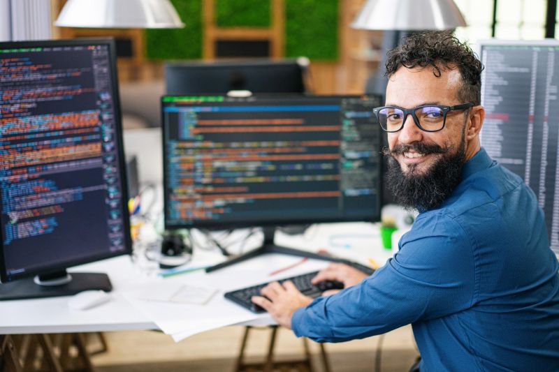 Smiling IT Programmer Working on Desktop Computer. Male Specialist Creating Innovative Software. Engineer Developing App, Program, Video Game. Writing Code in Terminal