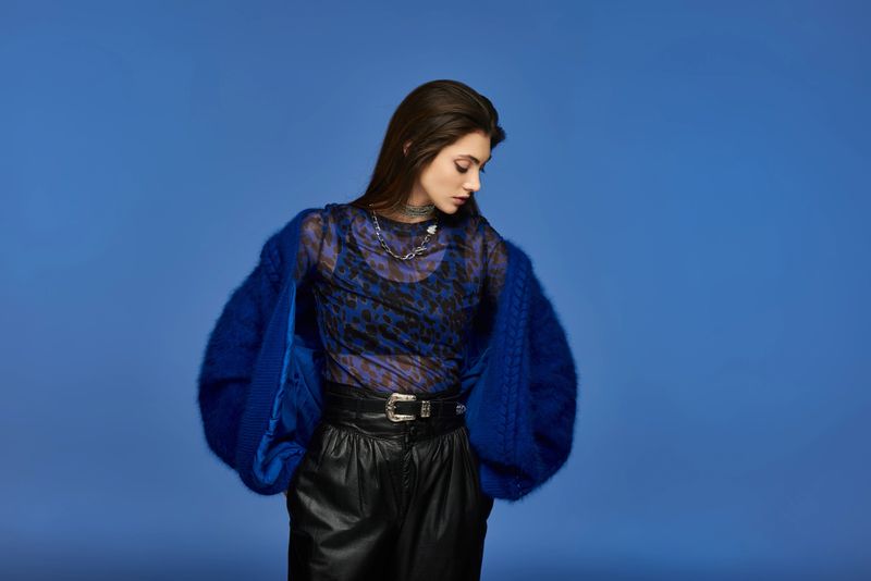A young woman showcases her unique fashion sense in an urban environment, exuding creativity.