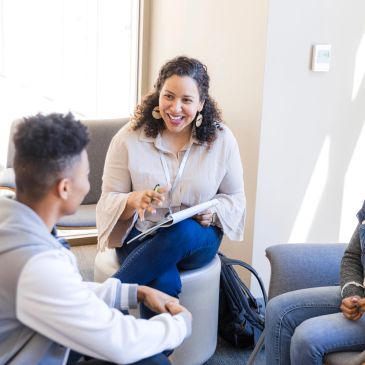 Three people having a friendly discussion indoors.