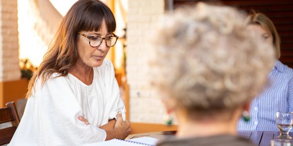A woman attentively listens during a counseling session on a couch.