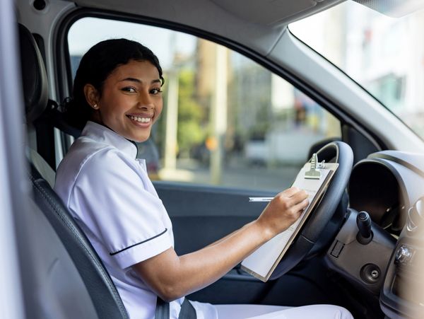Doctor consulting an elderly woman in a wheelchair with a tablet.