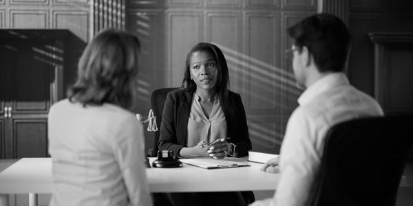 A woman mediating a conversation between a couple.