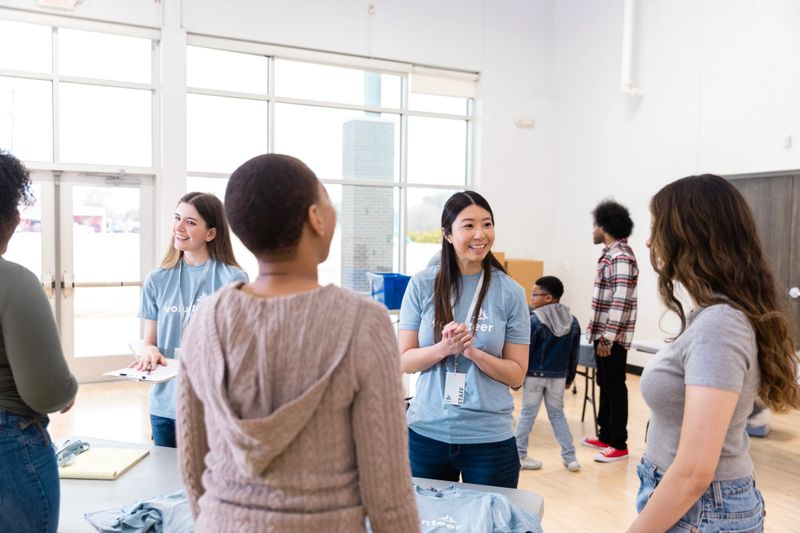 Happy diverse group of volunteers discussing during a community outreach event.