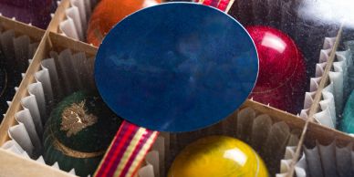 Colorful bowling balls in a cardboard box with a blue label.