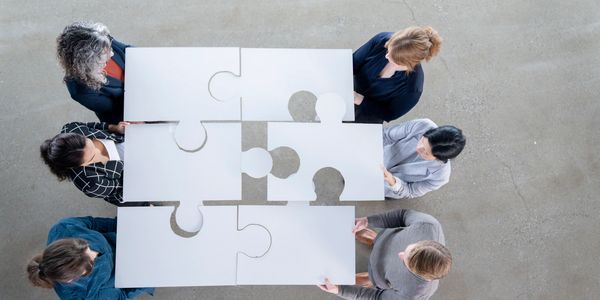 a team design build professionals assembling puzzle pieces. illustrating their  important roles 