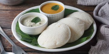 Plate of South Indian idlis with coconut chutney and sambar.
