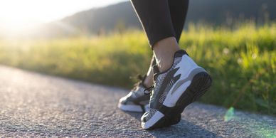 Close-up of running shoes on a sunlit path.