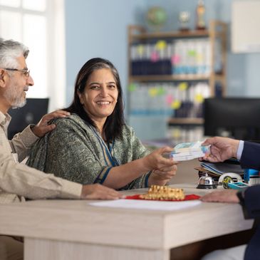 A couple receiving money from a businessman in an office.
