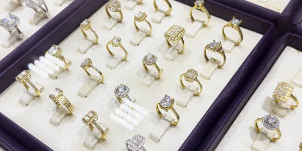 Display of elegant gold rings with sparkling diamonds in a jewelry box.