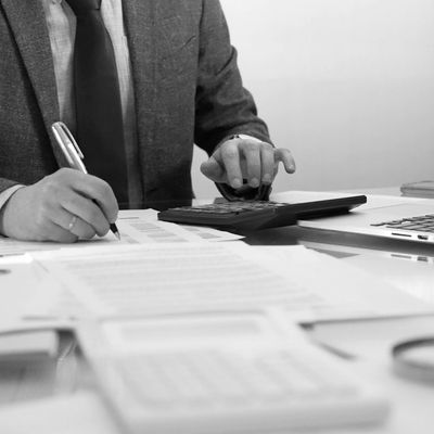 Person calculating finances with pen and calculator.