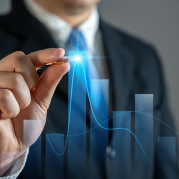 Businessman drawing a glowing upward graph bar.