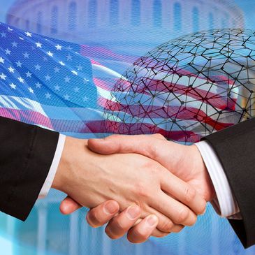 Business handshake with American flag and Capitol dome background.