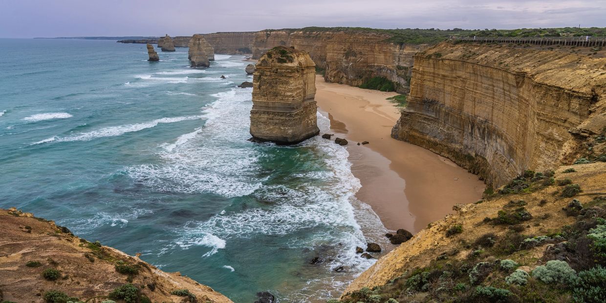 Rock formations along a rugged coastline with cliffs and waves.