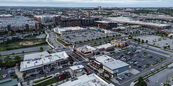 Aerial view of a suburban shopping center with multiple stores and parking lots.