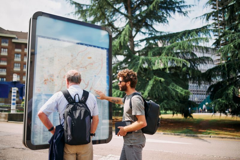 Man, tourist or travel with screen map in city for tour guide, location or destination. Male people, tourism or point of interest with geographic display for adventure, journey or sightseeing in town