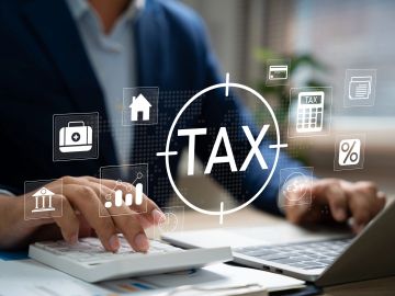 Businessman calculating taxes with digital icons representing financial concepts.