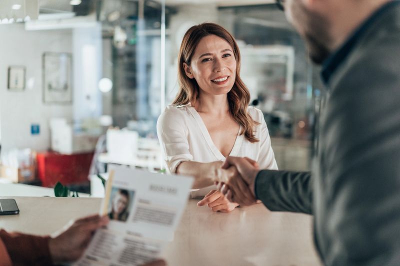 A poised candidate shakes hands with an interviewer, marking a pivotal moment in a job interview. This image encapsulates professionalism and the excitement of new opportunities in the career journey.