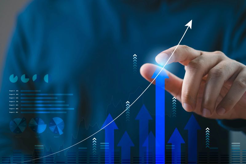 A person interacts with a digital graph, representing growth and success in business, highlighting future potential and technological advancement.