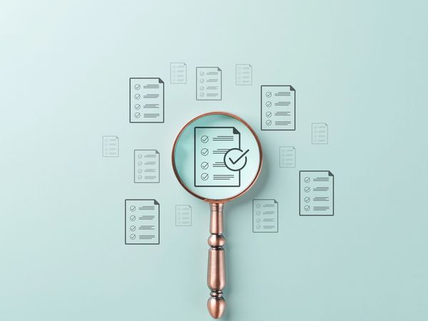 Magnifying glass focusing on a checklist icon among multiple checklists.