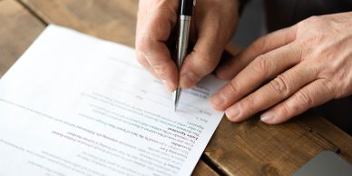 Person signing a document with a pen.