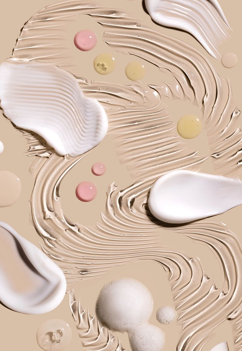 samples of cosmetic care products smear of cream gel texture close up on a beige background