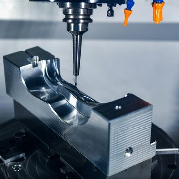 CNC machine milling a shiny metal mold with precision.