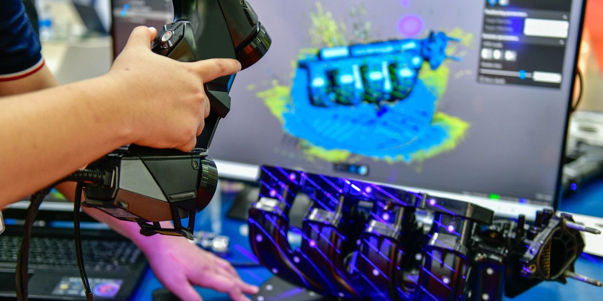 3D scanning of an engine part using a handheld scanner.