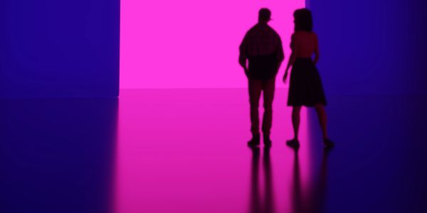 Silhouettes of two people walking toward a bright pink doorway in a dark, reflective room.