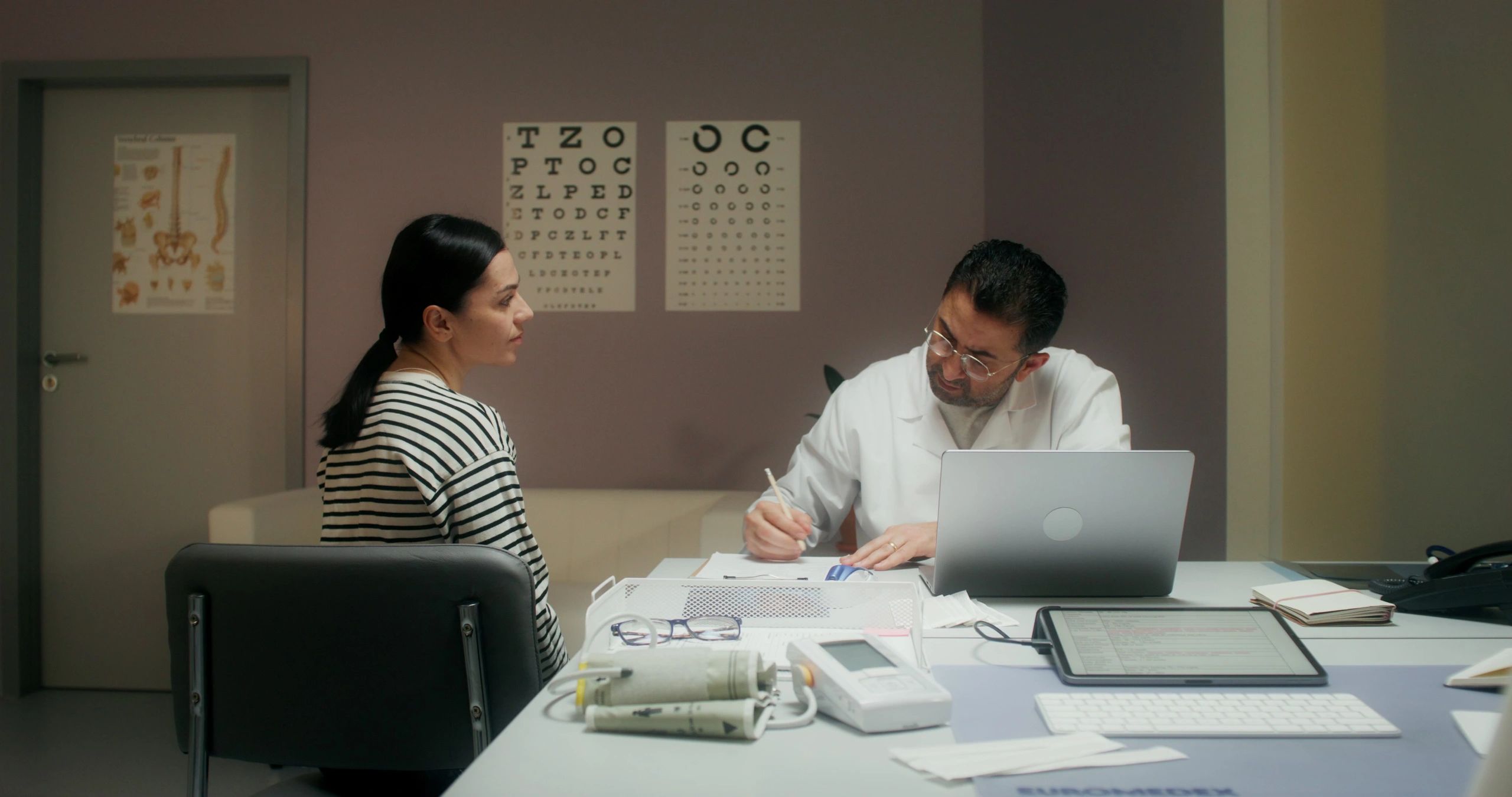 Doctor consulting female patient in an examination room.