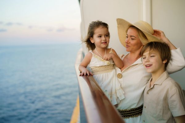 Mother and children enjoying a view on a ship deck.