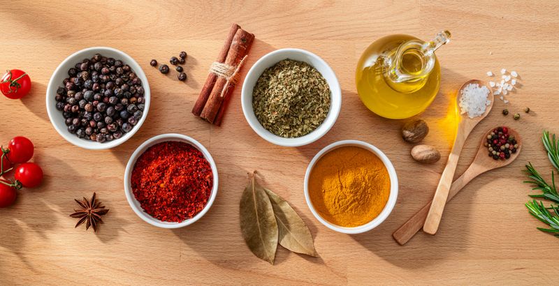 Bowls filled with spices and herbs shot from above on wood background