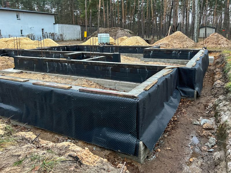 Foundations of a single-family house covered with dimpled foil, prepared for covering with sand and earth for better insulation against moisture.